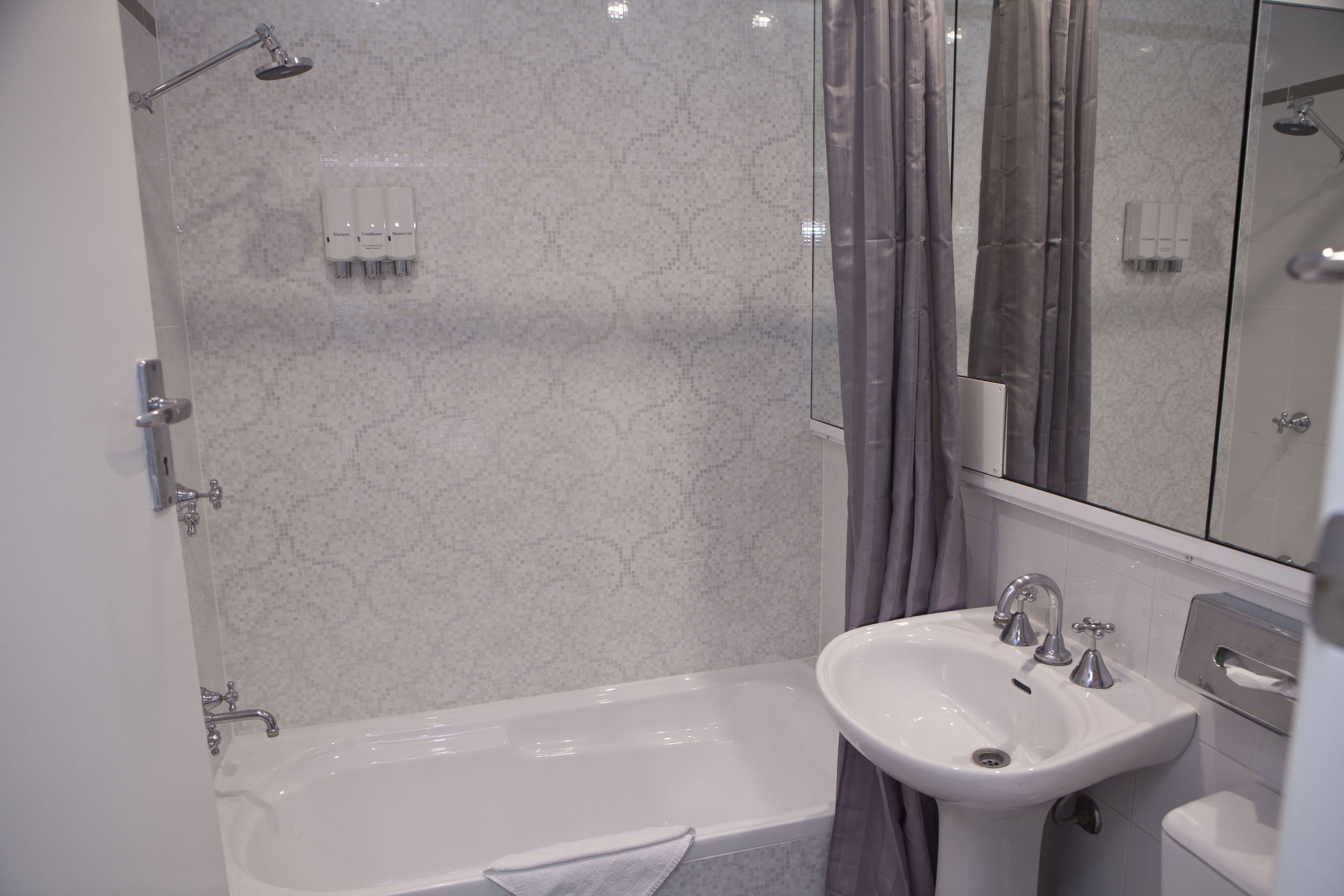Un baño con bañera, lavamanos y ducha.