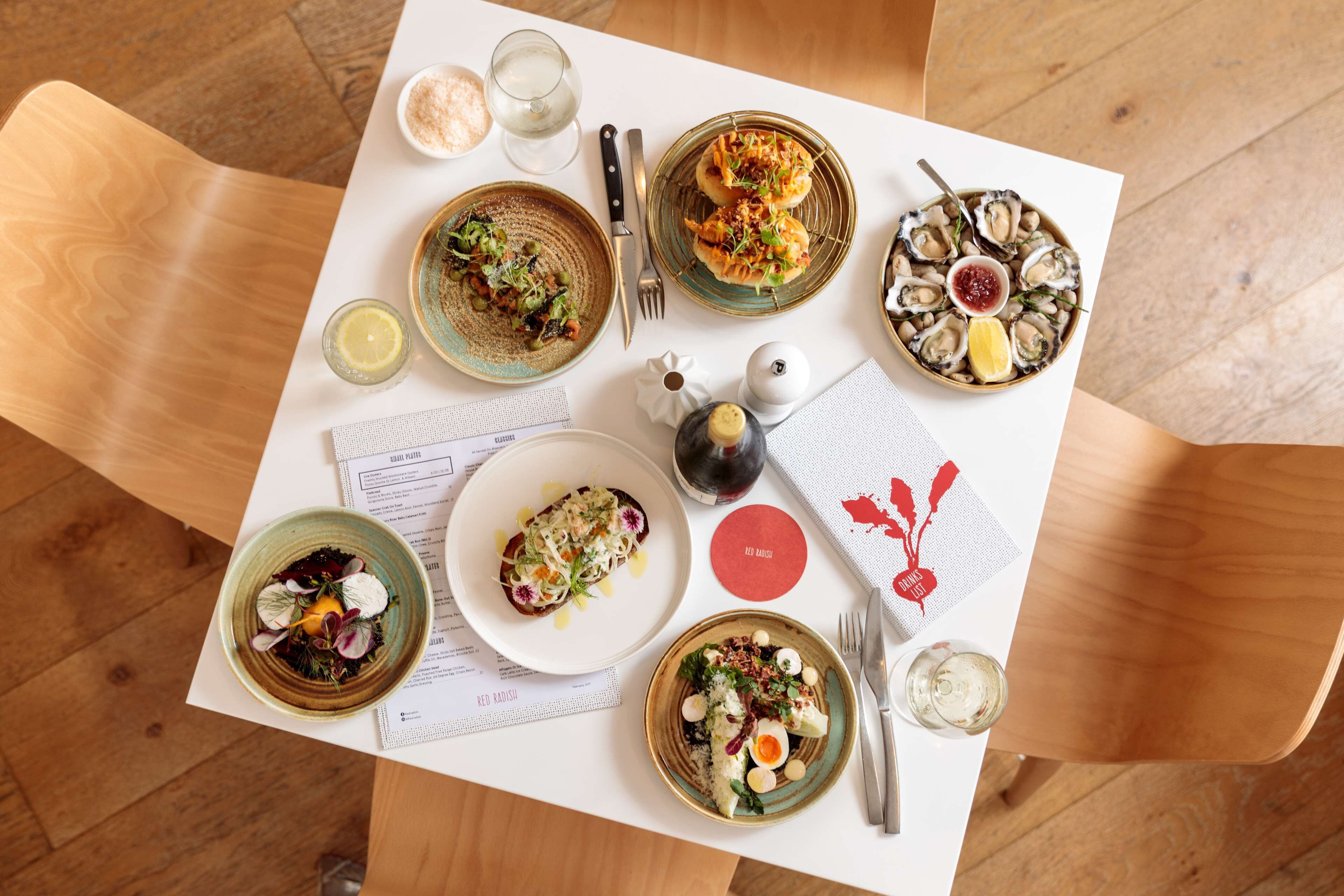 A table with various dishes, cutlery, and a menu.
