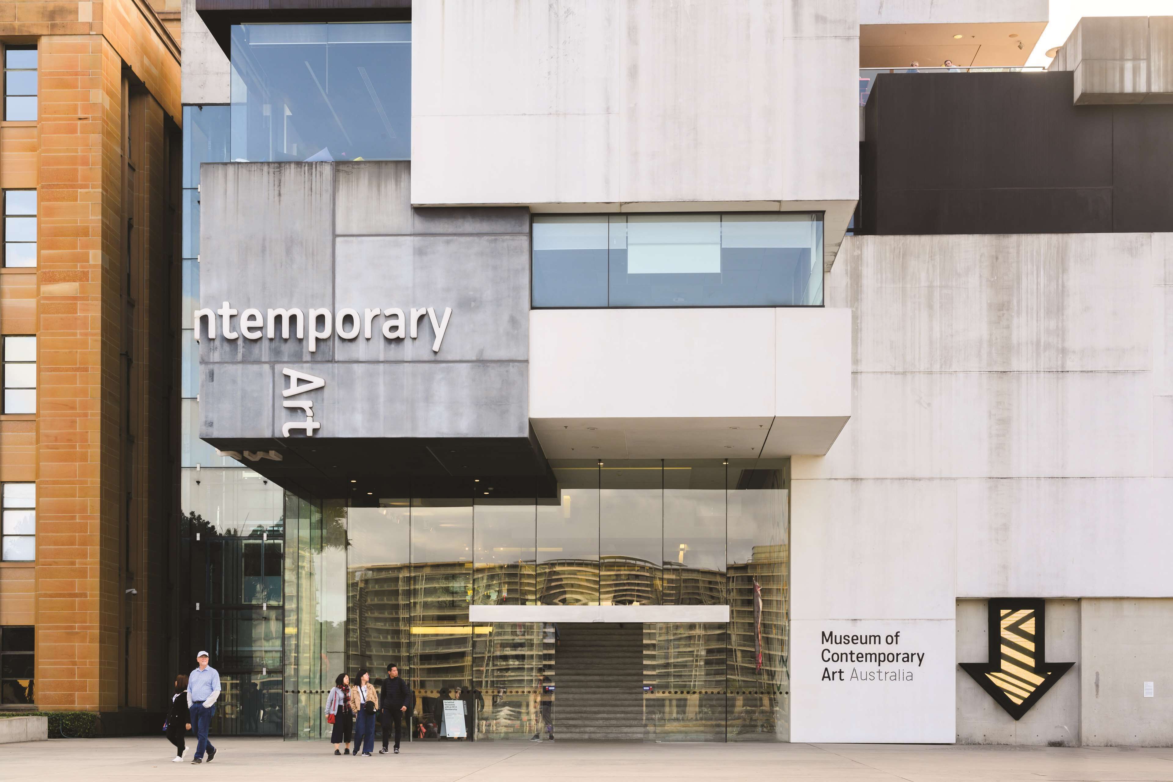 Het exterieur van het Museum voor Moderne Kunst Australië, met een modern architectonisch ontwerp, met een opvallende ingang en duidelijke bewegwijzering.