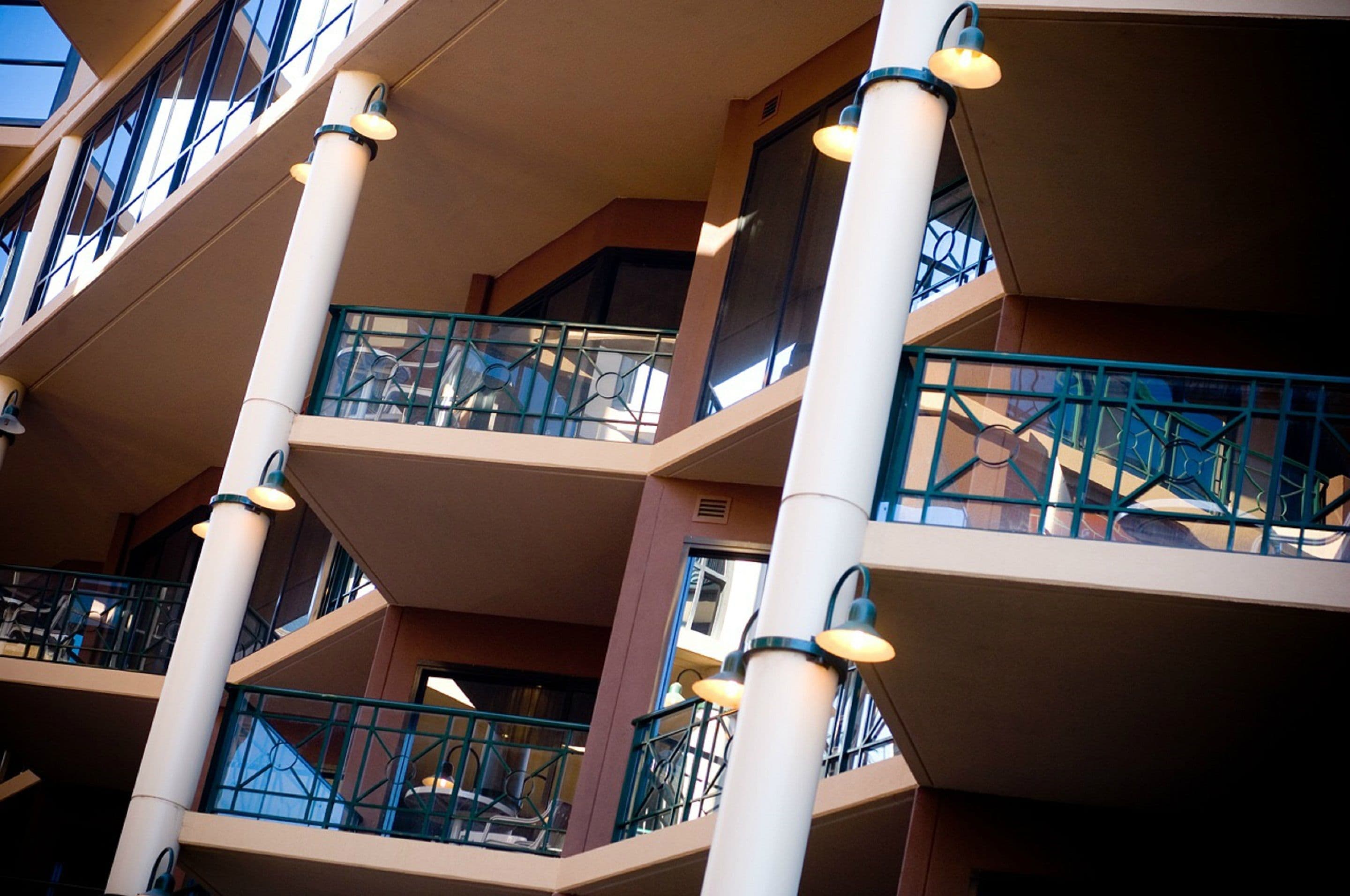 Un atrio de varios niveles con balcones, barandillas e iluminación.