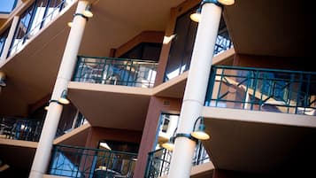 Un atrio de varios niveles con balcones, barandillas e iluminación.