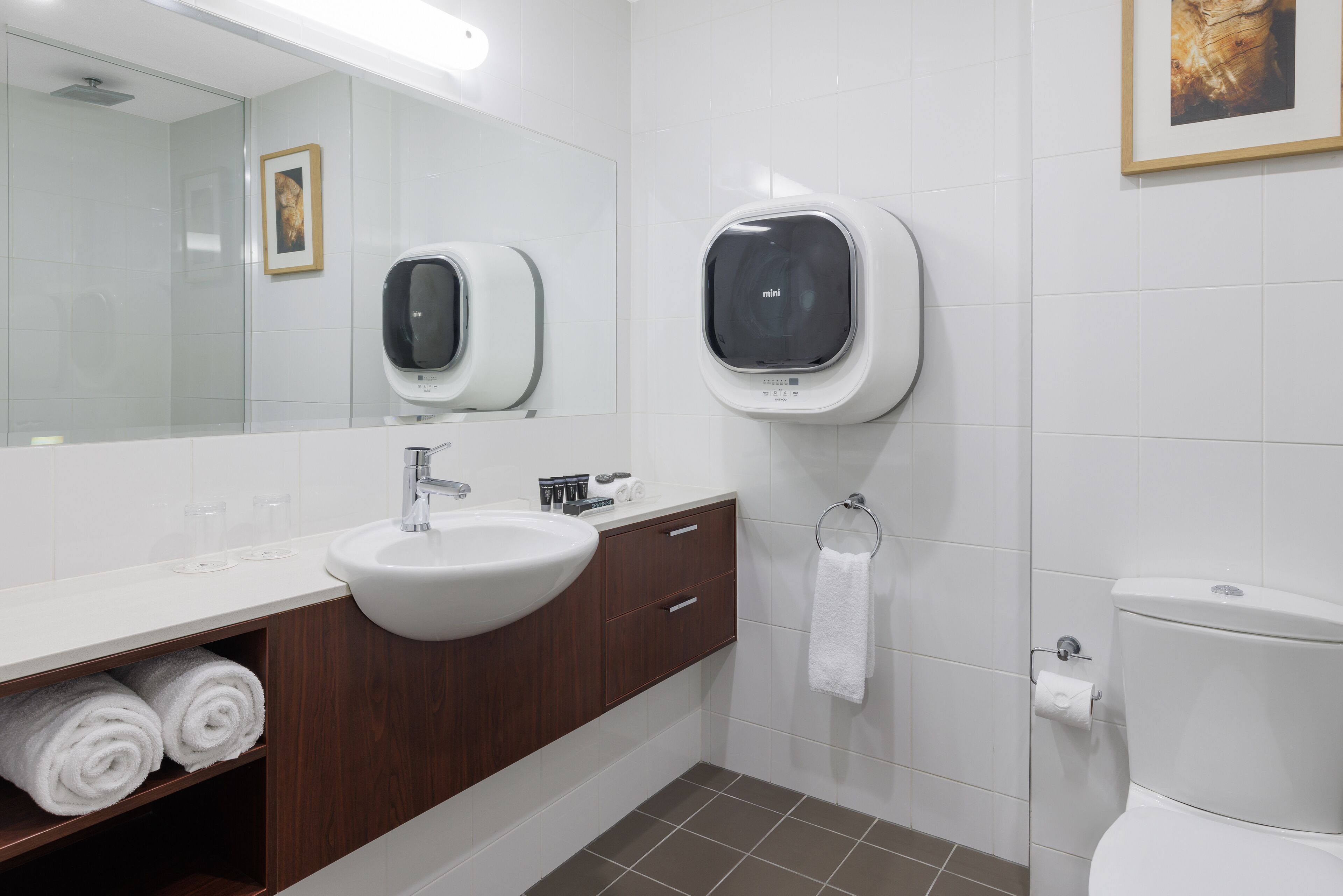 Une salle de bain moderne avec un lavabo blanc, un meuble-lavabo en bois et des toilettes.