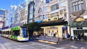 A tram passing by a Zara store with a modern glass facade and a classic building with ornate details. - Mercure Melbourne City Centre (Melbourne)