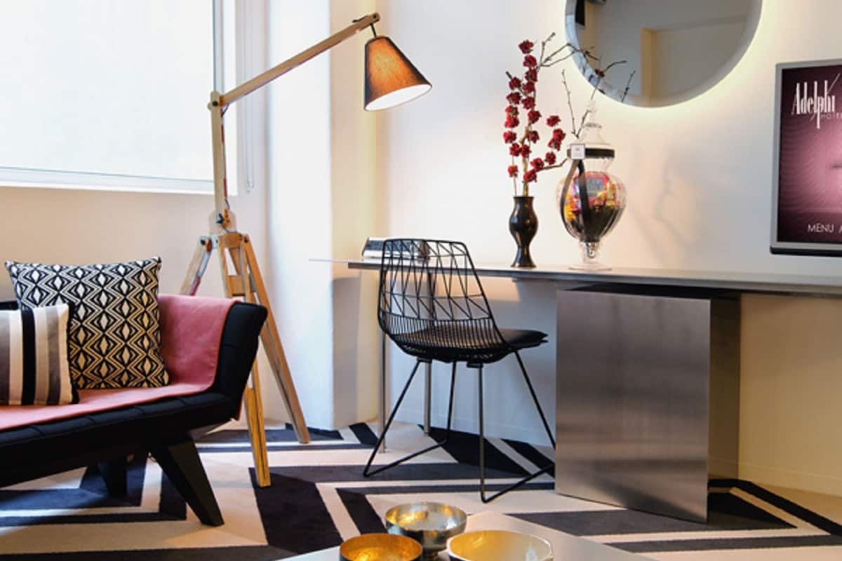 A modern living room with a sofa, a coffee table, a lamp, and a mirror.