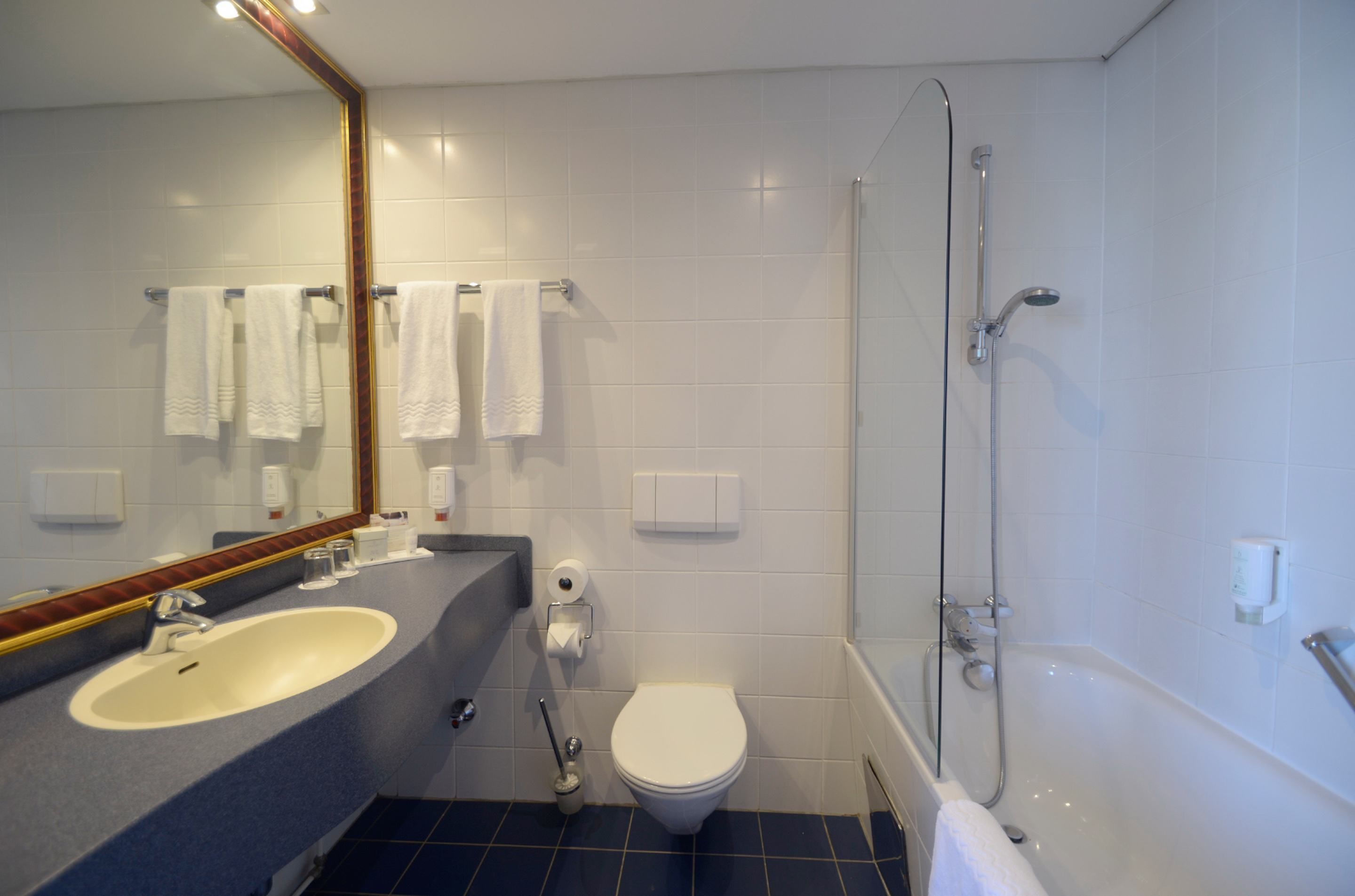 Een moderne badkamer met wastafel, toilet en douche.