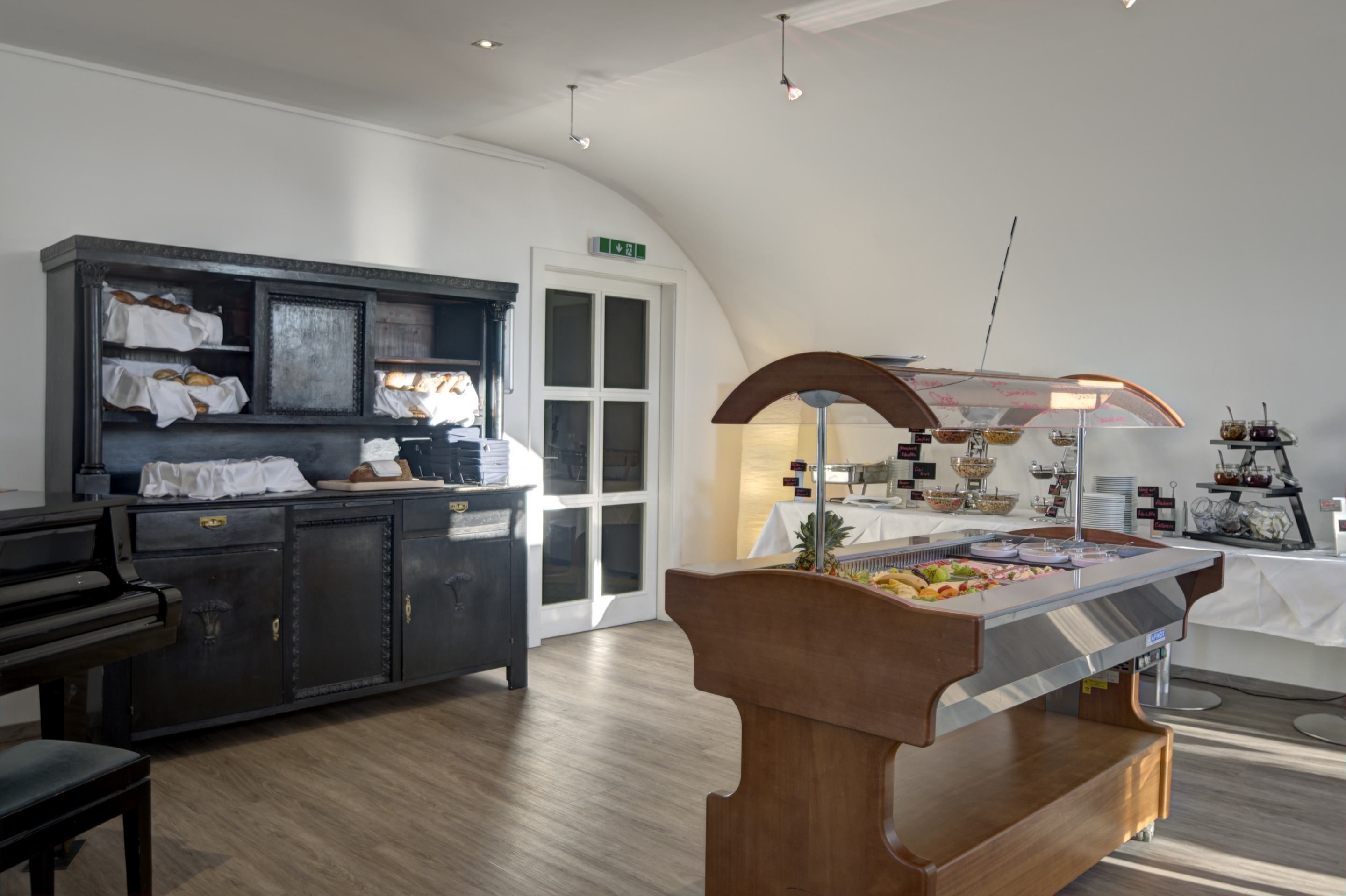 Eine moderne Hotelhalle mit Klavier, einem Buffetbereich und einer Rezeption.