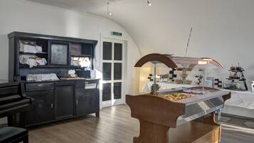 Eine moderne Hotelhalle mit Klavier, einem Buffetbereich und einer Rezeption.