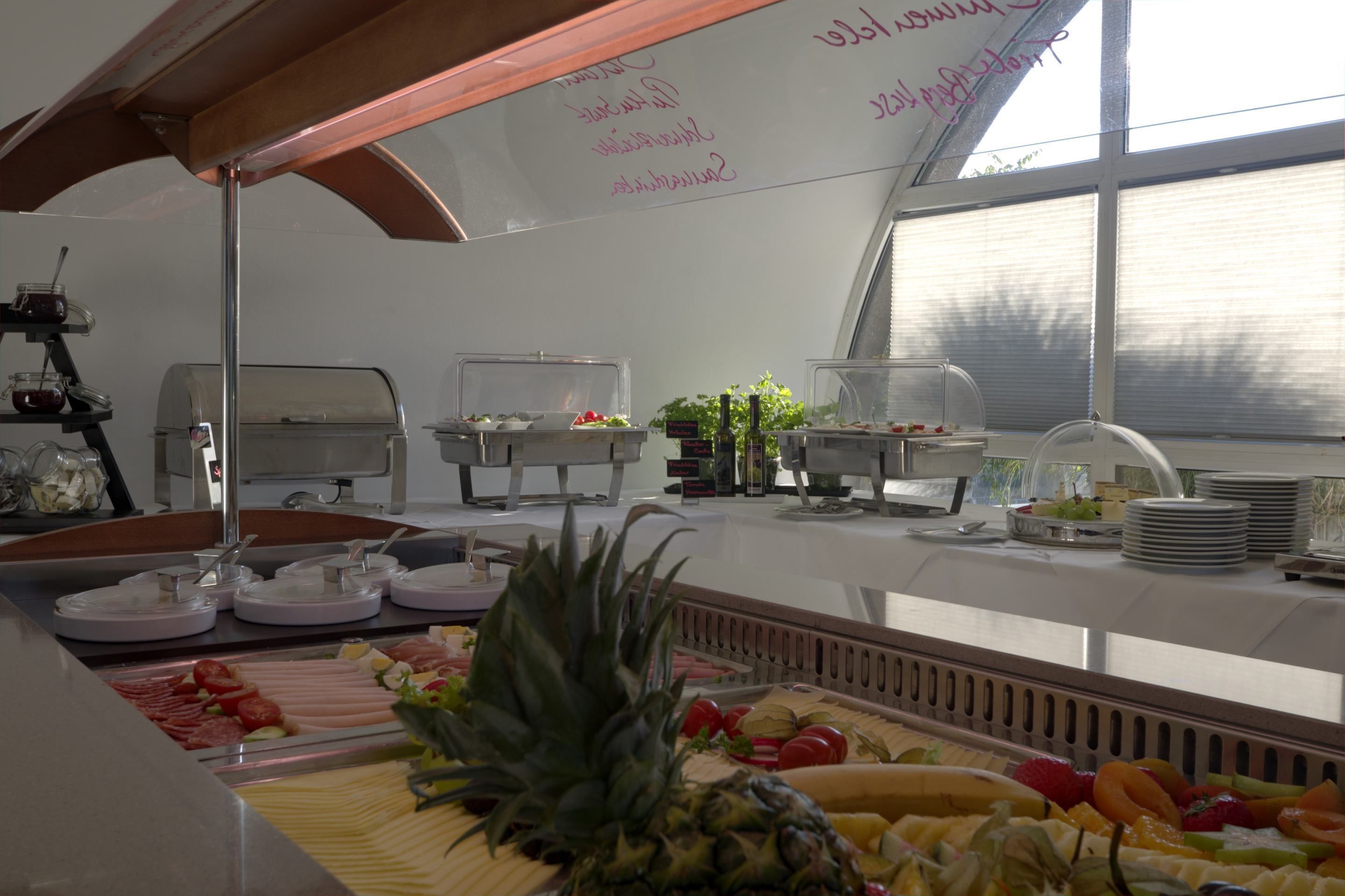 A buffet setup with various food items and a whiteboard with handwritten notes.