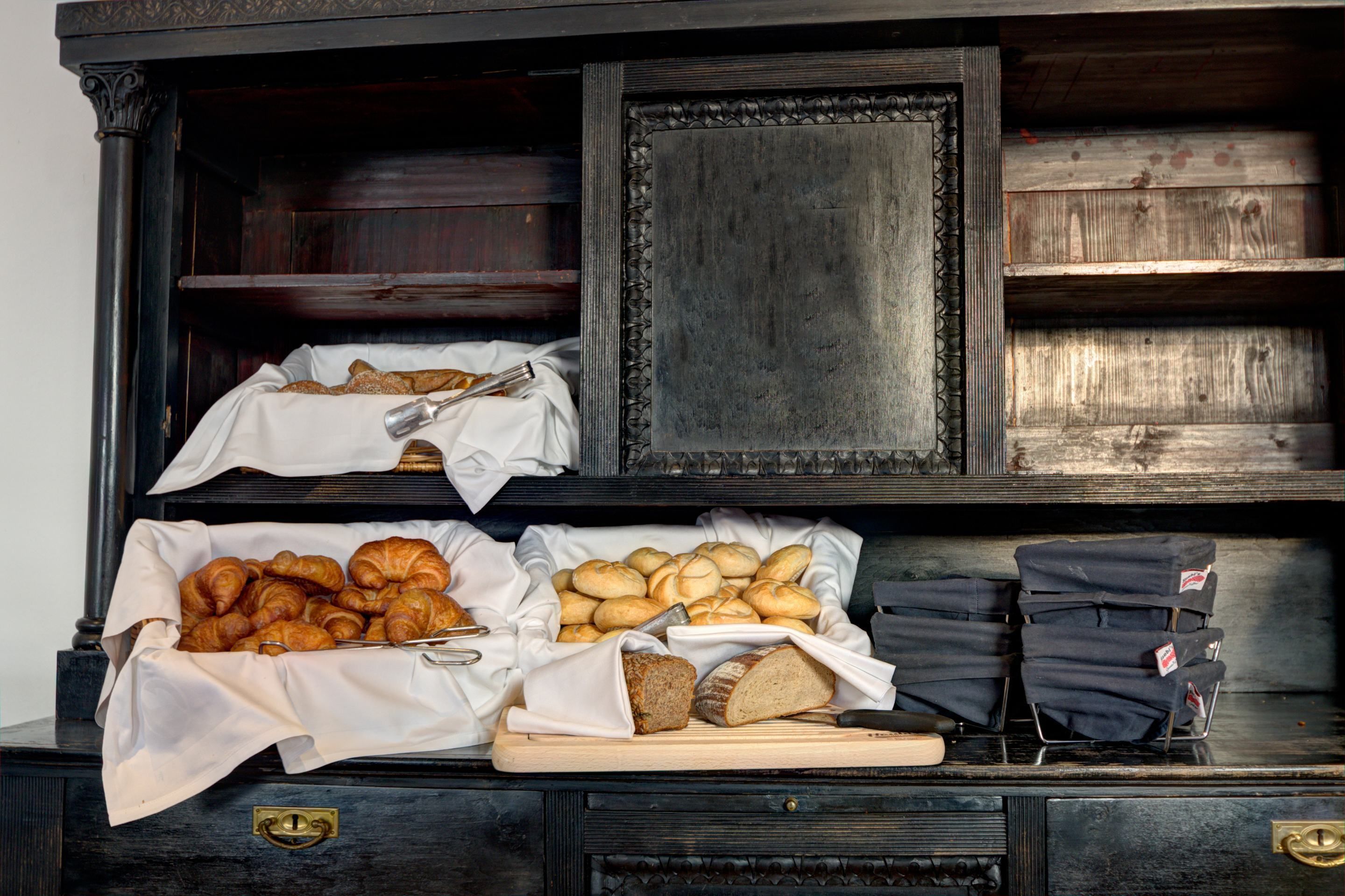 Ein Buffet mit verschiedenen Backwaren, darunter Croissants, Brot und Gebäck.