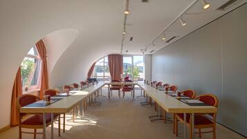 Ein Konferenzraum mit einem langen Tisch, Stühlen und großen Fenstern.