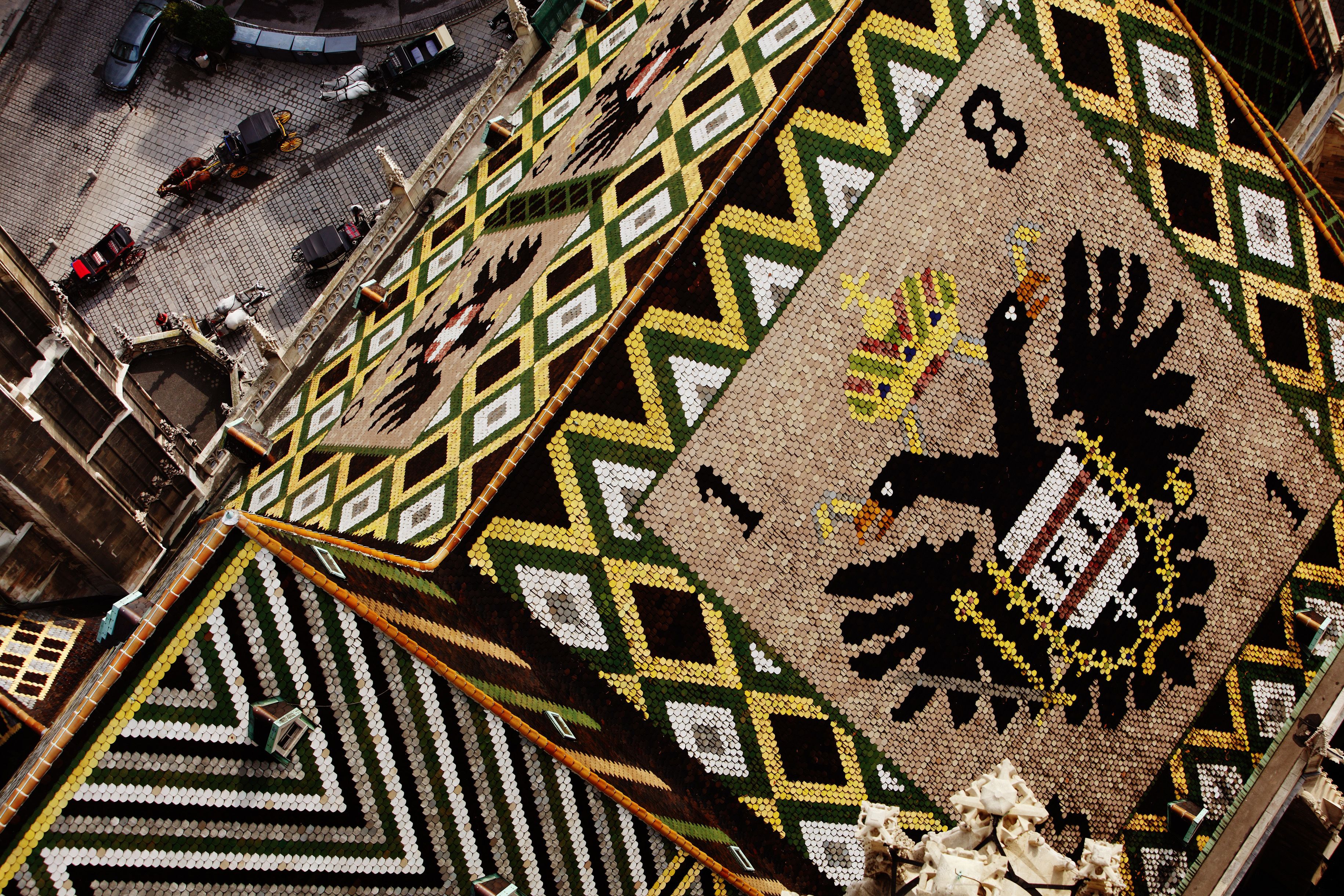 Un paviment mosaic amb patrons geomètrics i un emblema al centre.