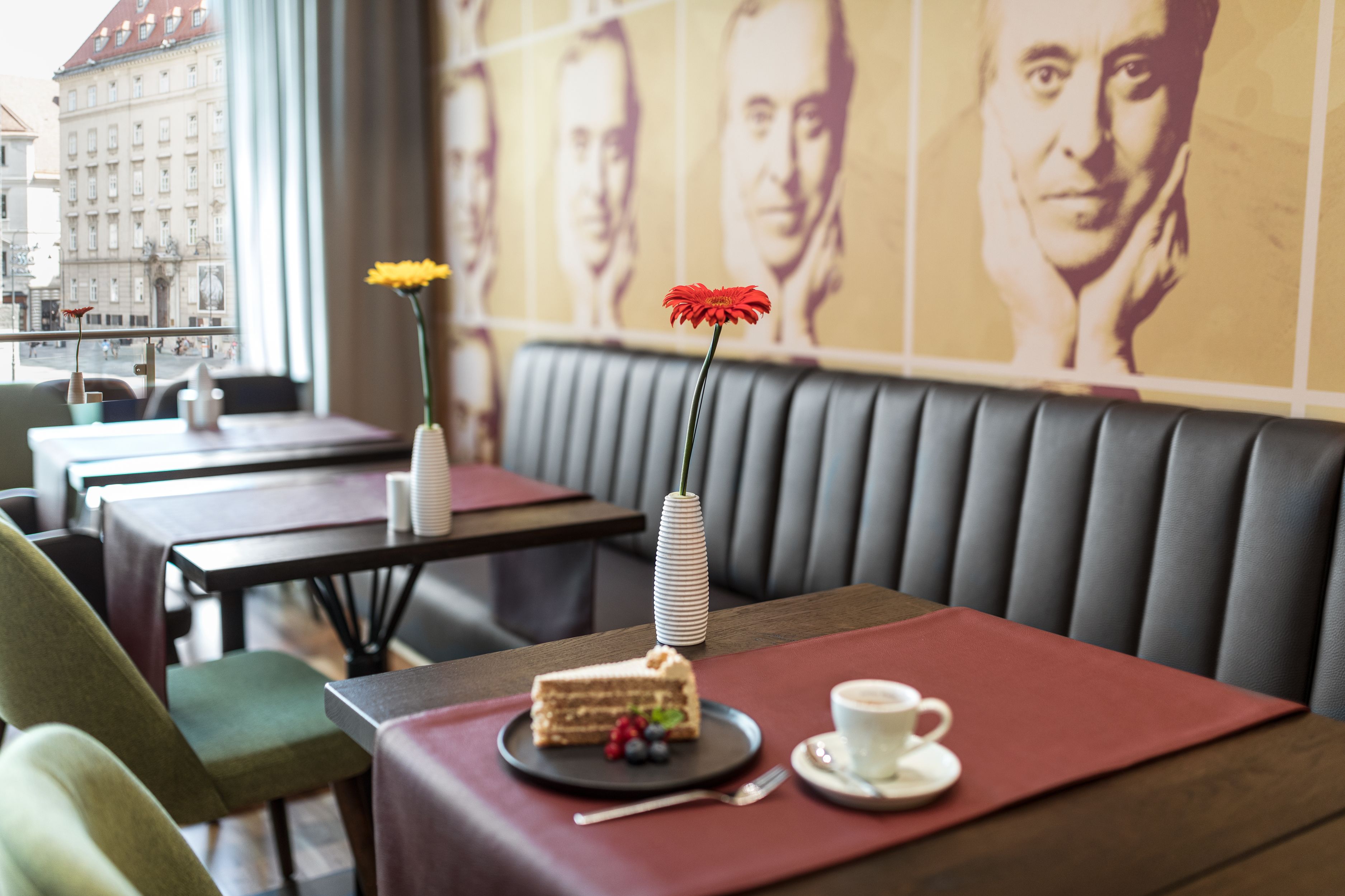 Ein Restaurant mit einem Tisch, gedeckt mit Kuchen, Beeren und einer Tasse Kaffee.