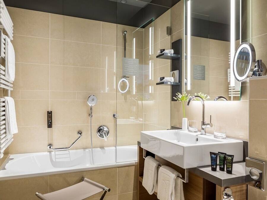 Un baño moderno con bañera, tocador con espejo y zona de ducha.