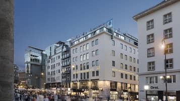Ein Hotel mit modernem Design, das eine markante Glasfassade und mehrere Balkone aufweist.