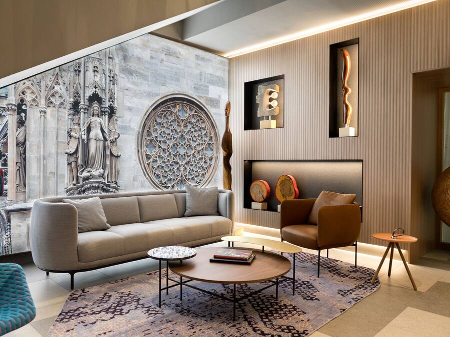 A modern living room with a large window, a sofa, a coffee table, and decorative items on the wall.