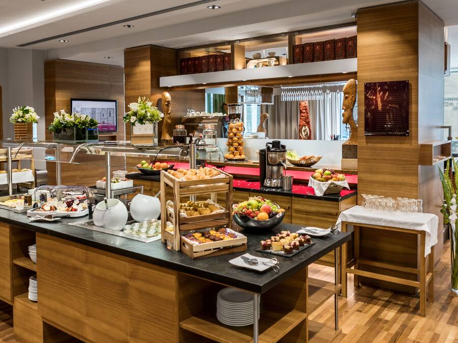 Un buffet proposant une variété de plats, un coin café et un espace détente avec vue.