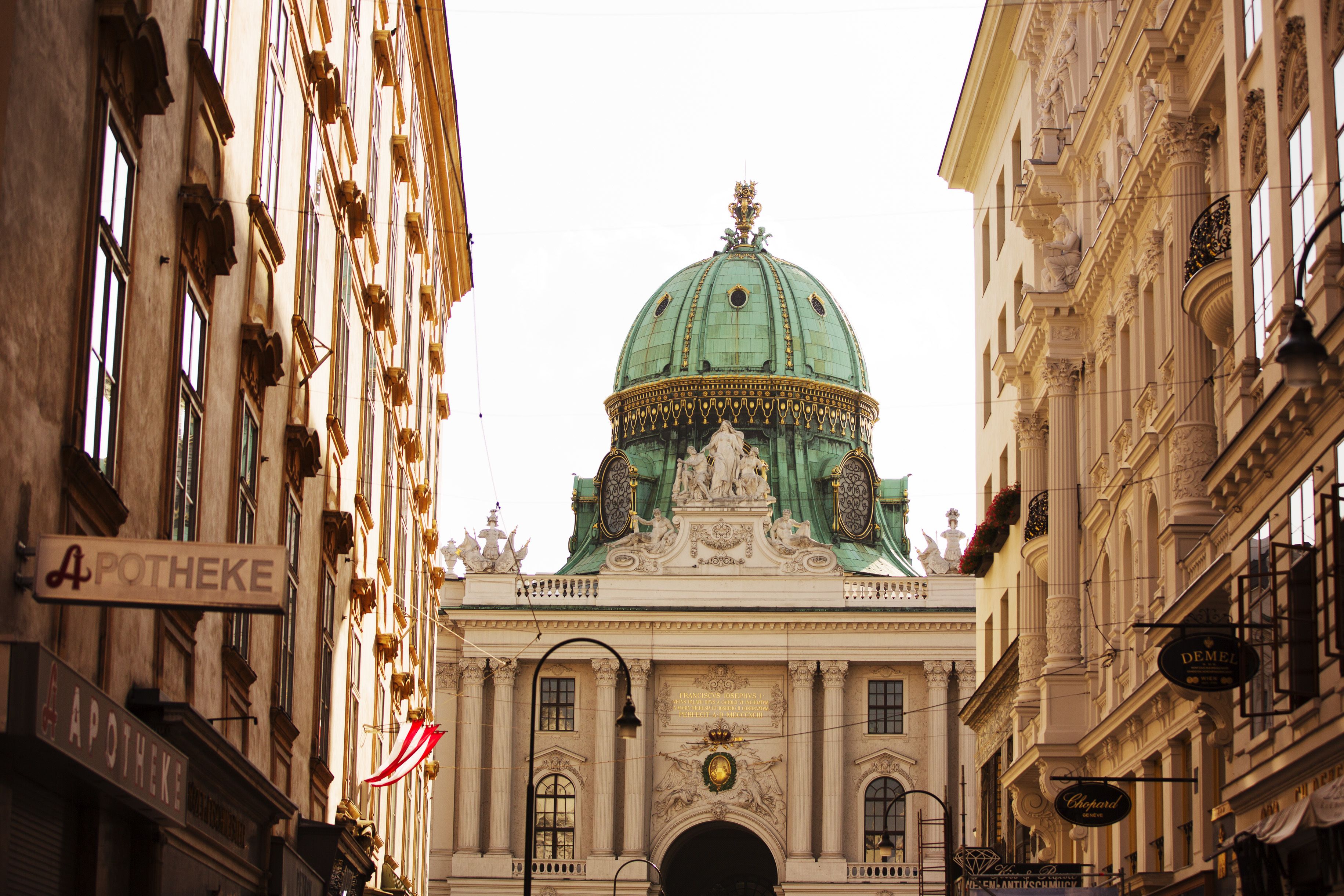 Un edificio histórico con una cúpula verde destacada y arquitectura clásica.