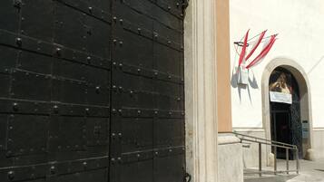 A large black metal door with rivets and a metal handle.