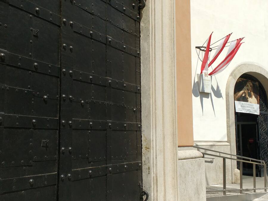 A large black metal door with rivets and a metal handle.
