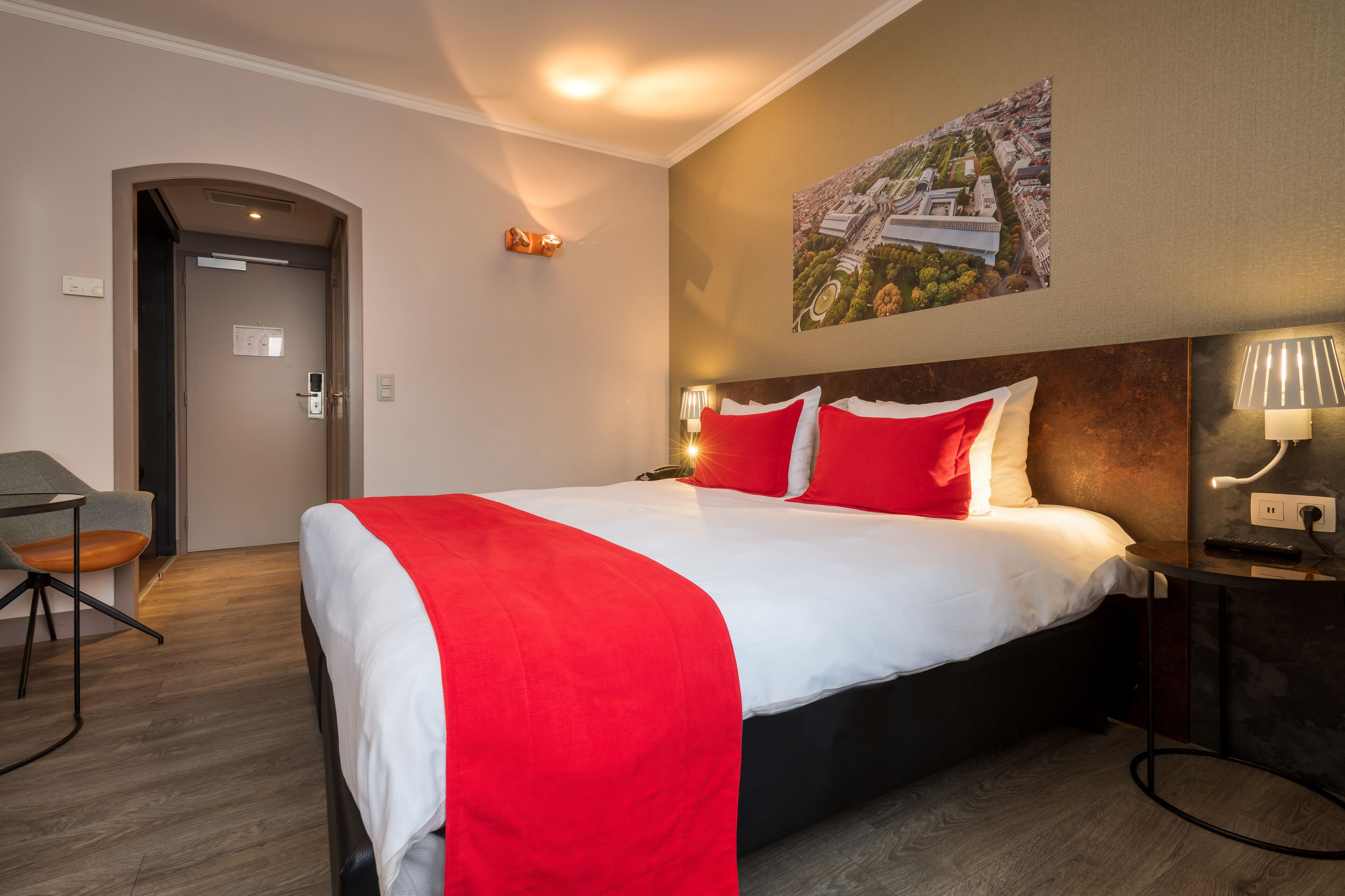 Habitación de hotel con cama, escritorio y una silla.