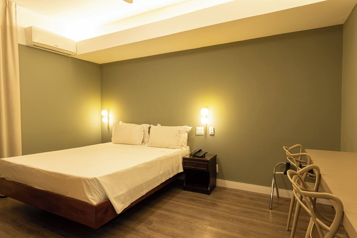 Une chambre à coucher comprenant un lit, une table de chevet, une commode et une chaise.