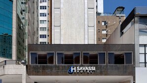 A modern building with a Savassi Hotel sign, featuring a central atrium with a glass facade and a parking garage below. - Savassi Hotel (Belo Horizonte)