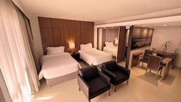 A hotel room with two beds, a desk, a chair, and a large mirror.