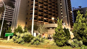 Un hôtel de grande hauteur, avec de nombreux étages, des balcons et une entrée imposante.