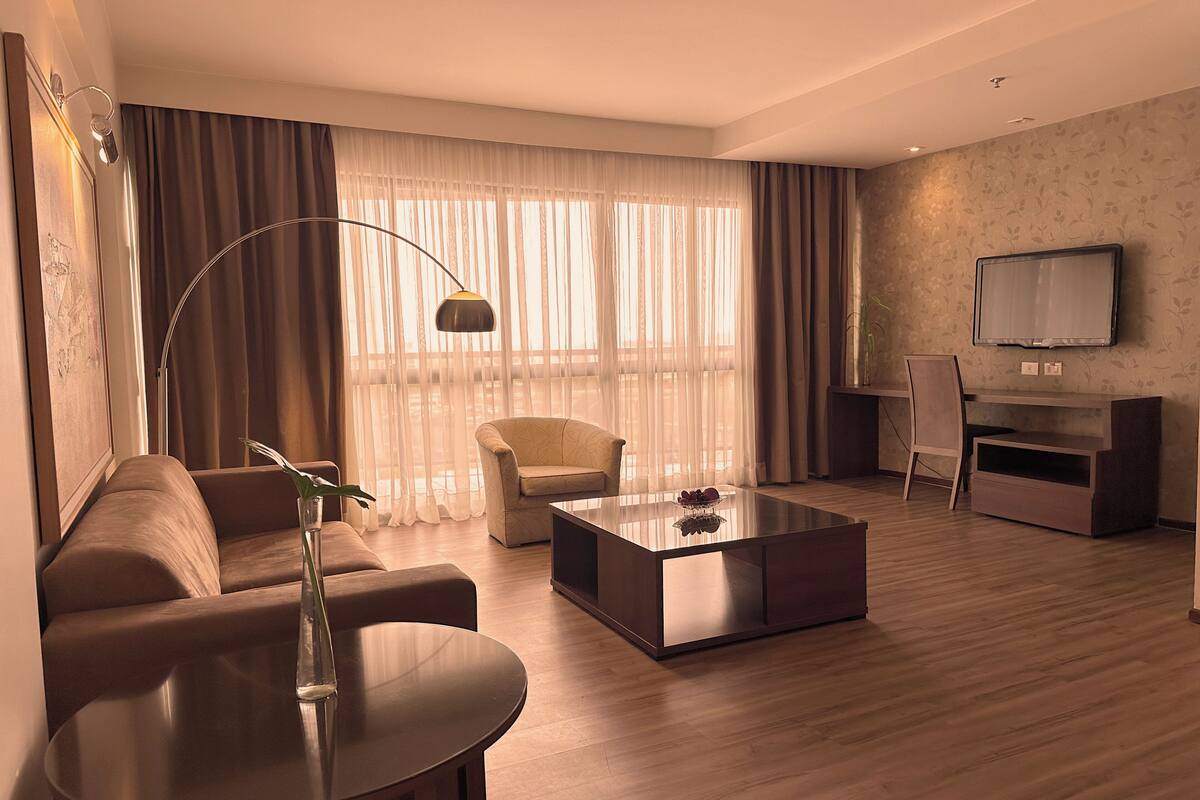 Una sala de estar moderna con un sofá, una mesa de centro, un televisor y un escritorio.