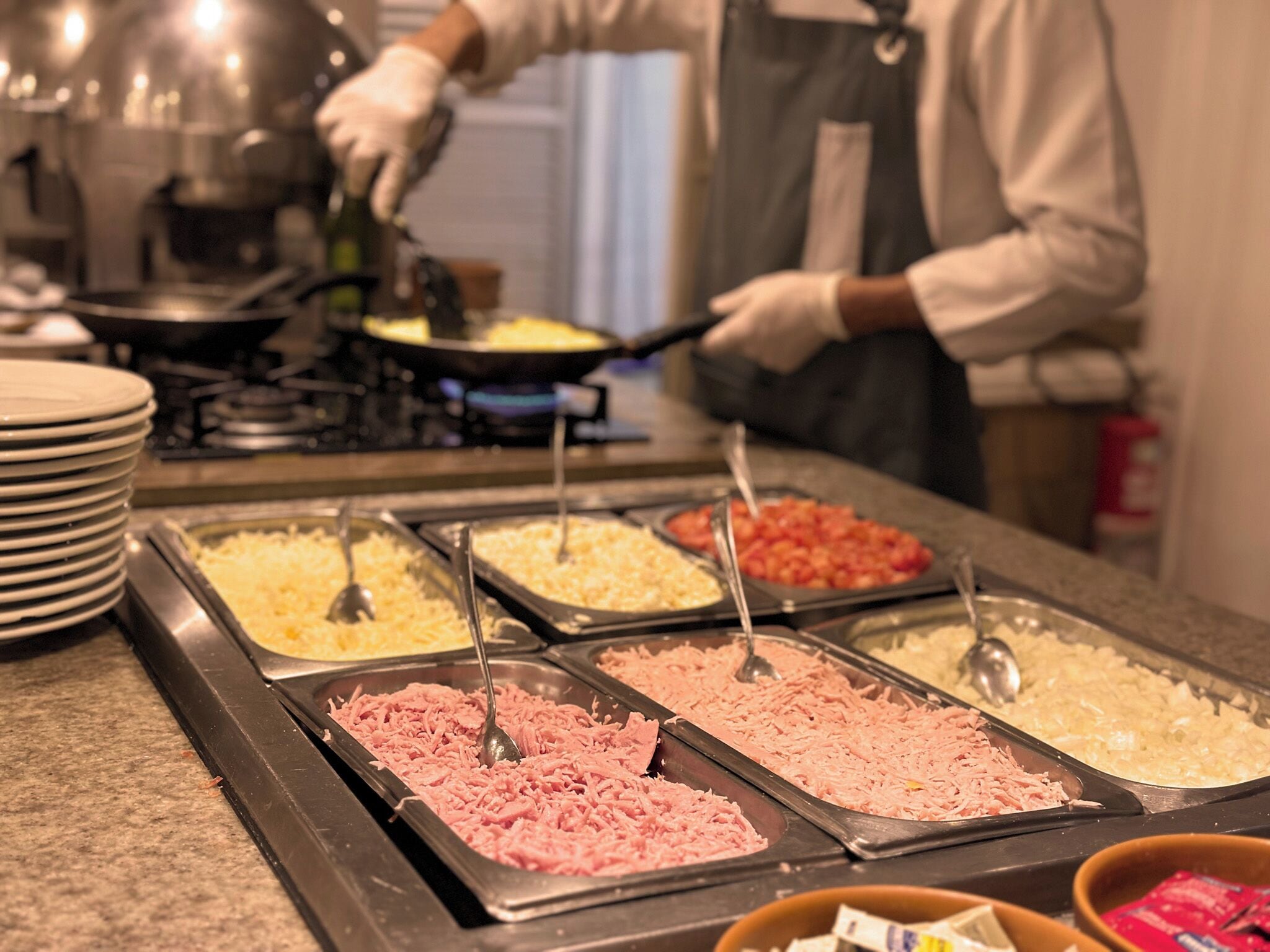 Un buffet proposant une variété de plats, notamment de la viande effilochée, du fromage et d’autres mets.