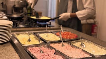 A buffet with various food options including shredded meat, cheese, and other dishes.