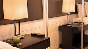 Una habitación de hotel con una cama, mesitas de noche, lámparas y un espejo que refleja el cuarto.