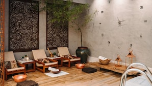 A modern spa room with wooden furniture, a large decorative wall panel, a potted plant, and a wall clock. - San Marco Hotel Brasilia Executivo (Brasília)
