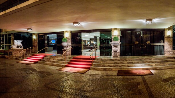 A grand entrance with a marble staircase, a red carpet, and statues. - San Marco Hotel Brasilia Executivo (Brasília)