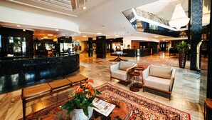 A spacious lobby with a reception desk, seating area, and a large chandelier. - San Marco Hotel Brasilia Executivo (Brasília)