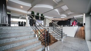 A modern interior with a staircase, a reception desk, and a view of the lobby area. - Slaviero Baía Norte Florianópolis (Florianópolis)