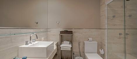 A modern bathroom with a glass shower enclosure, a white sink with a mirror, and a toilet.