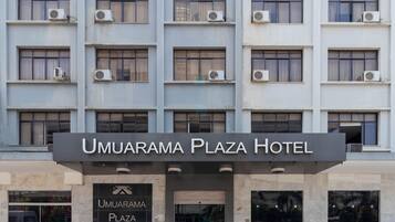 Exterior do Hotel Umuarama Plaza, com fachada moderna, unidades de ar condicionado e uma placa.