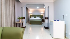 Una habitación de hotel con cama, escritorio, silla y planta en maceta.