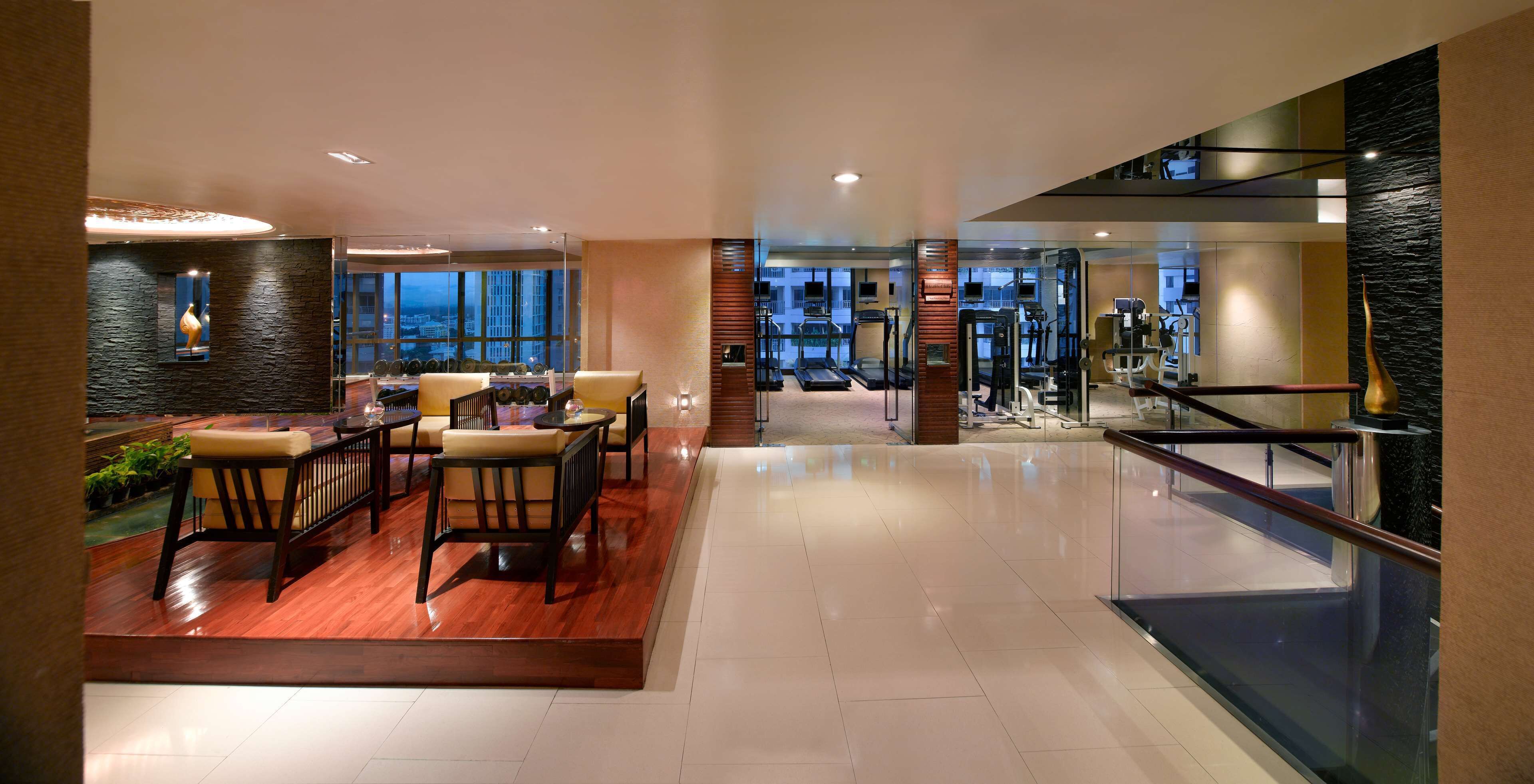 En modern hotellobby med en matplats, träningsutrustning och utsikt över stadsbilden.