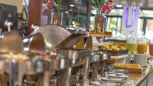 A buffet setup with various food items and beverages. - Littoral Hotel (João Pessoa)