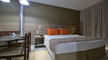 A hotel room with a bed, a desk, and chairs.