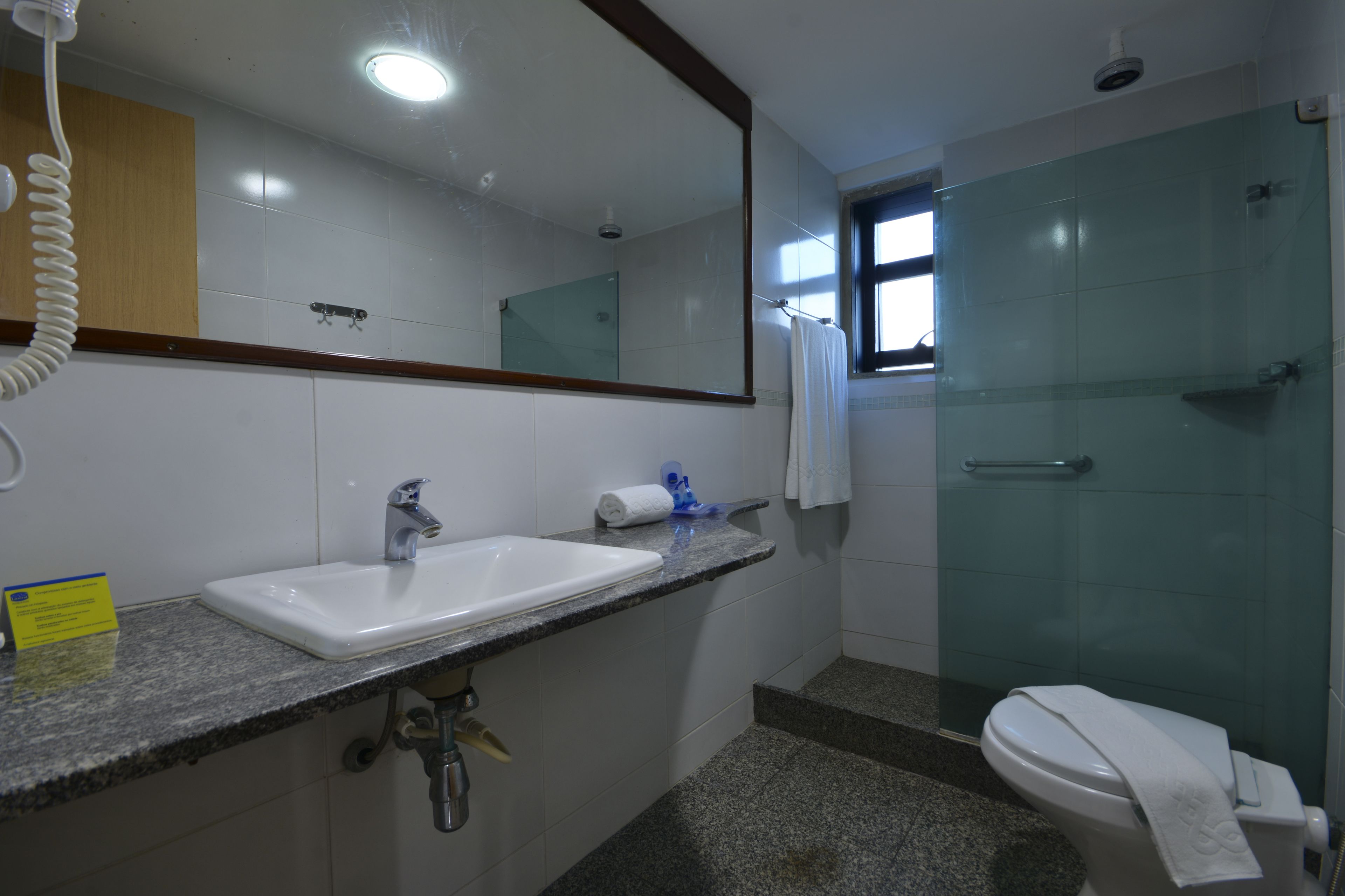 A bathroom with a sink, mirror, and glass shower enclosure.