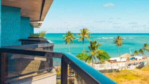 A balcony with a view of the ocean and palm trees. - Maceio Atlantic Suites (Maceió)