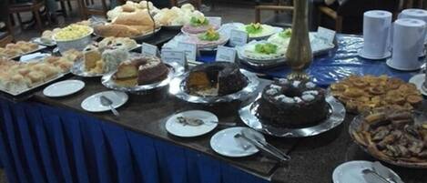 A buffet table with various food items and a cake.