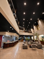 Un hall amplio con una recepción, zona de estar y un entrepiso.