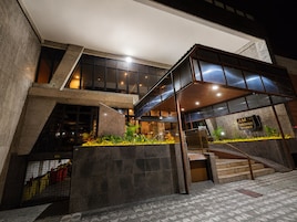 Un edificio moderno con fachada de vidrio, una escalera y un letrero que dice 'AM Precious Stones'.