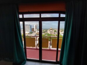 A room with a large window overlooking a cityscape, including a prominent building with a dome. - GoldMen Business Manaus - Taj Mahal (Manaus)