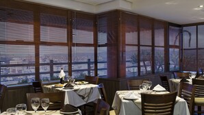 A restaurant with multiple tables, each set with wine glasses, plates, and cutlery. - Piazza Navona Porto Alegre by Intercity (Porto Alegre)