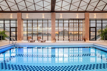 Una piscina techada, sillones reclinables de piscina